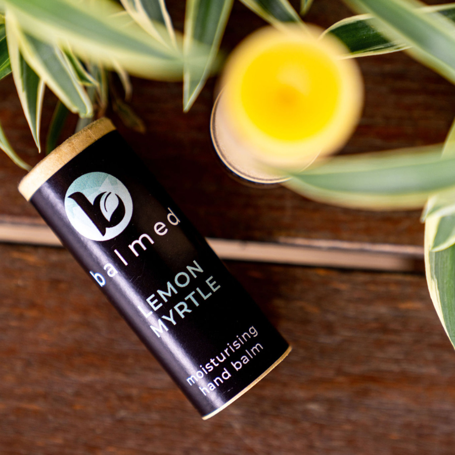 Lemon Myrtle hand balm stick lying on a wooden table